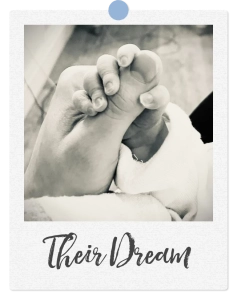Newborn baby holding an adult’s finger
